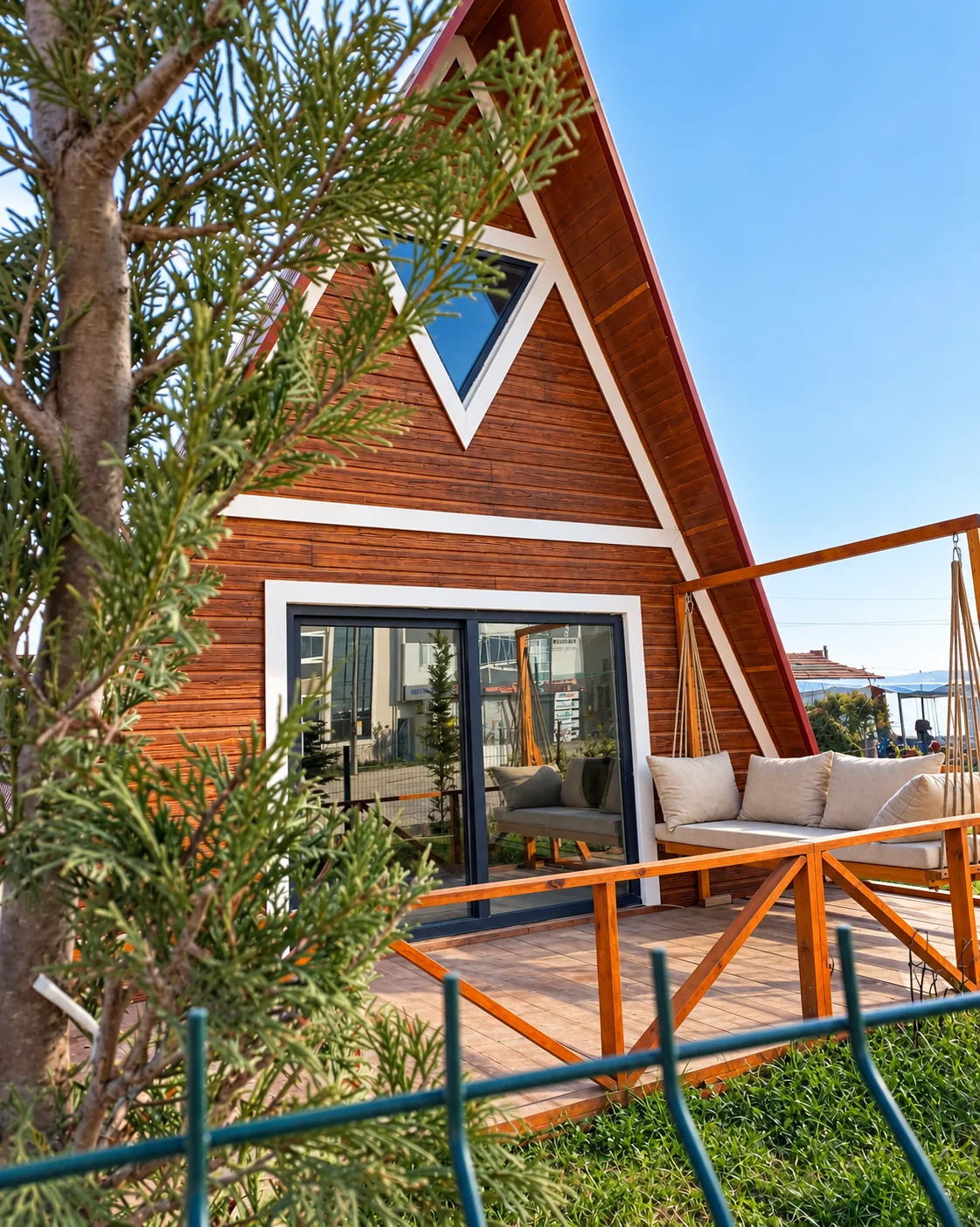 Ağaçlar arasında A-frame yapı ve veranda